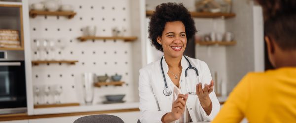 Portrait of female doctor, showing something to little patient.